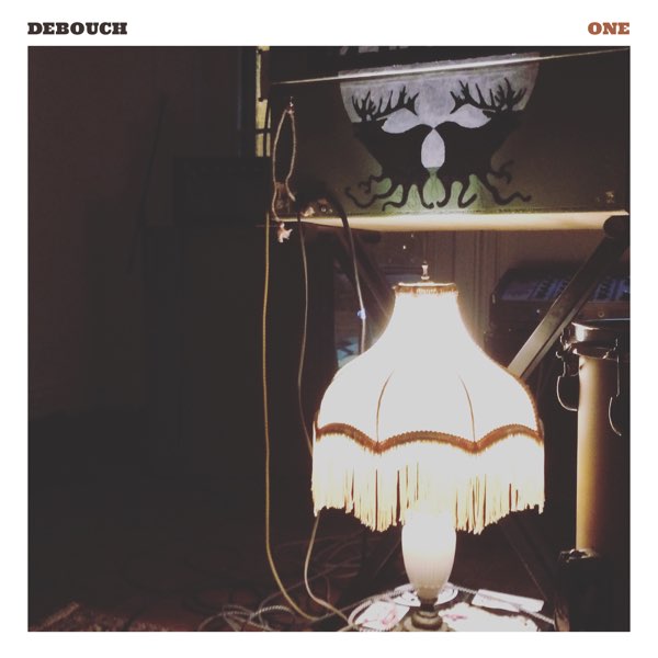 One album cover - a small lamp, which is on, sitting in front of Nic's gear setup.